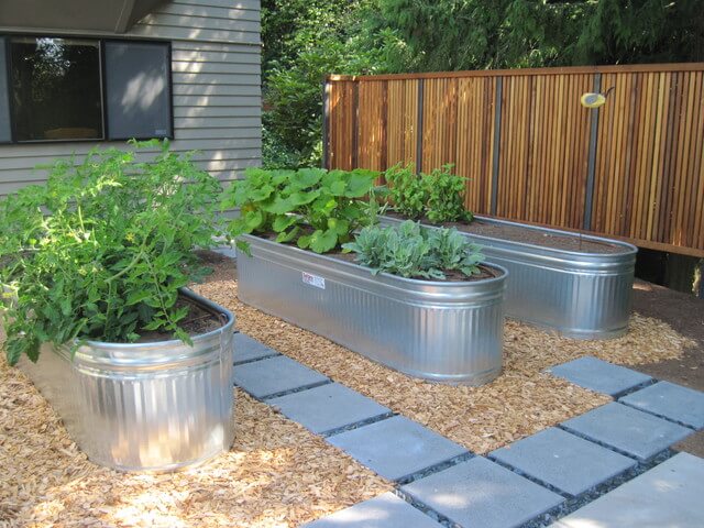 Three raised beds in galvanized metal troughs