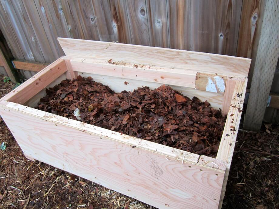 worm bin filled with a dirt, then a layer of leaves