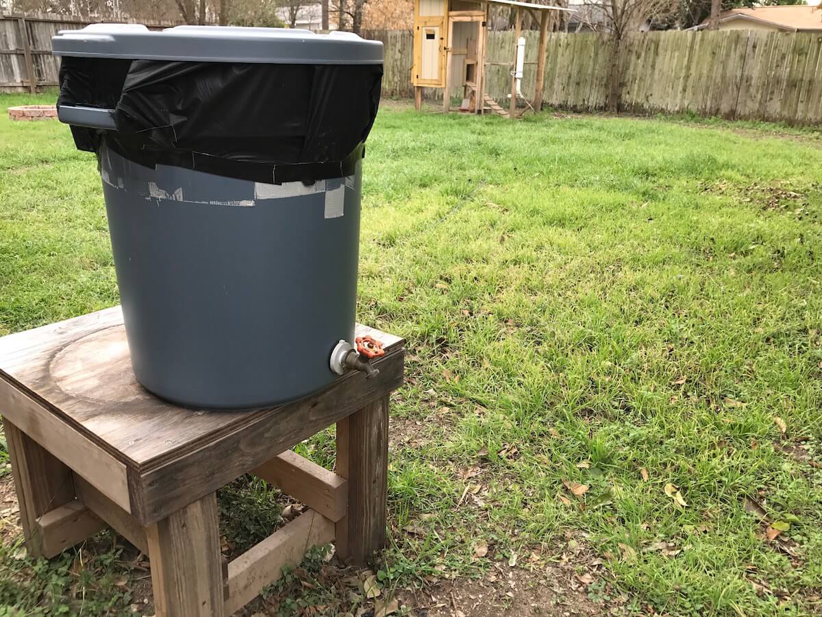 a rain barrel in a backyard