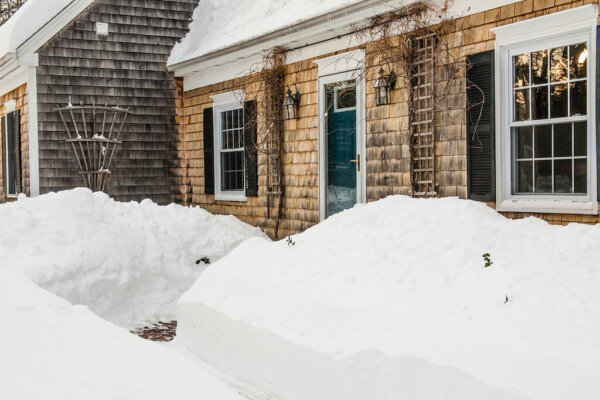 piles of snow outside of a home