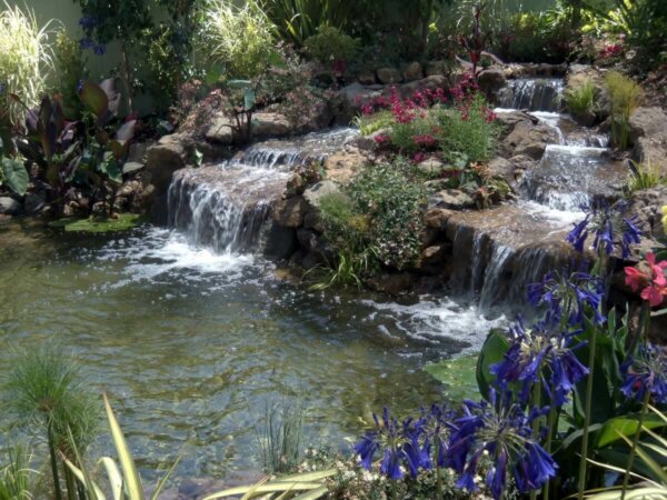 man made backyard water feature with two waterfalls