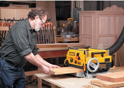 yellow dewalt planer being used by woodworker