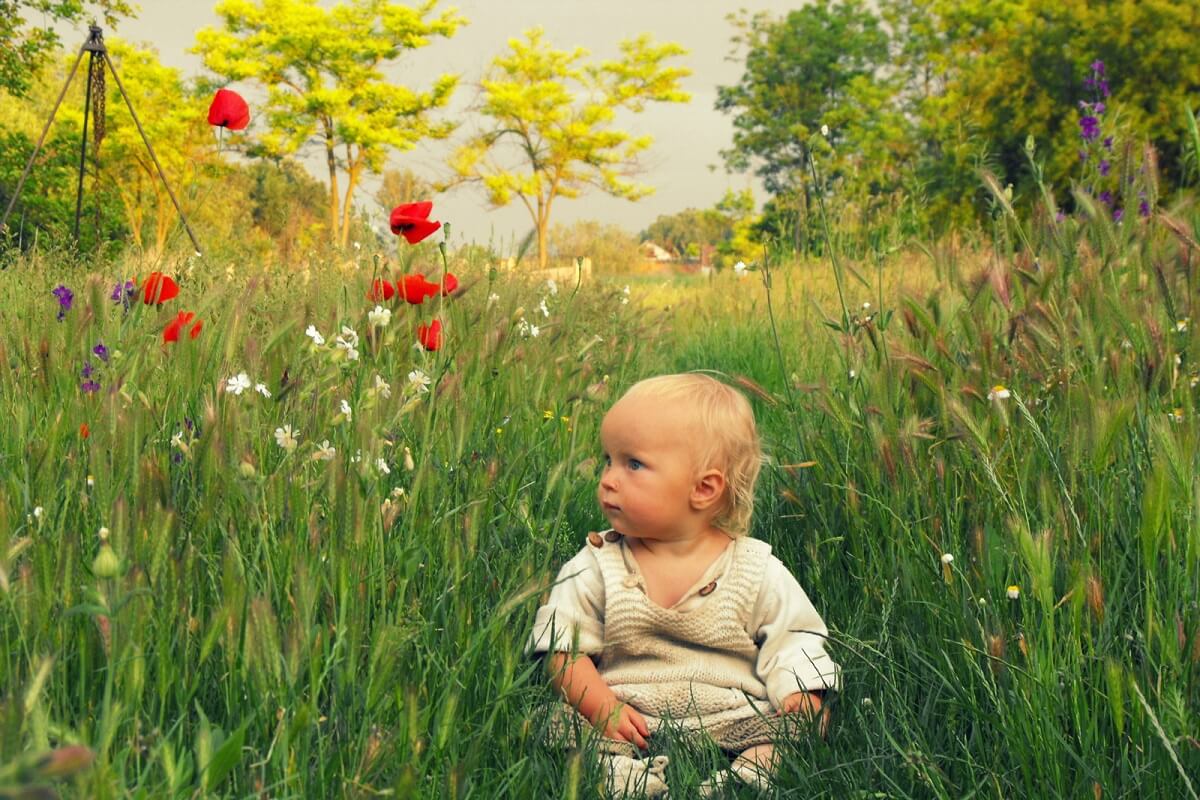 baby sitting in meadow