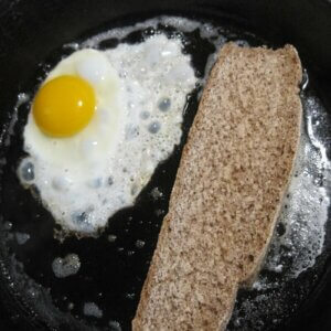 铸铁平底锅，里面有鸡蛋和面包