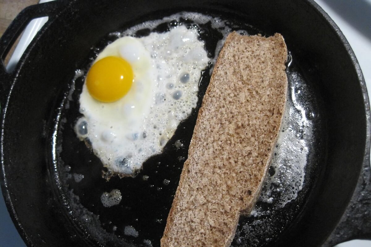 cast iron pan with eggs and bread